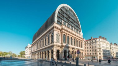 Lyon 'un opera binasının modern cam kubbe çatısı ile birleştirilmiş neoklasik mimarisi. Mavi gökyüzünün altında heykelleri olan tarihi ve turistik bir yer. Yan görünüm zaman dilimi