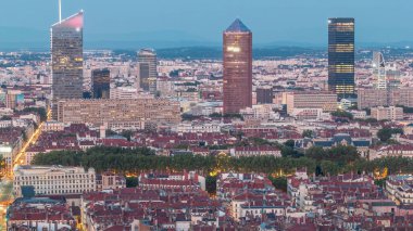 Gün batımından sonra Lyon 'un panoramik hava görüntüsü Fourviere Hill' den gece dönüşümüne kadar. Gökdelenler gökdelenlerle çevrili ve sıcak bir akşamda aydınlanan ikonik şehir simgeleri yer alıyor.