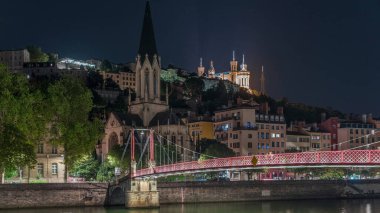 Aziz George Kilisesi, Quais de Saone ve Fourviere Bazilikası 'nın Fransa' nın Vieux Lyon kentindeki bir yaya köprüsünden hızlandırılmış zaman aşımına uğraması, geceleri tarihi mimari, yansımalar ve manzaralı nehir manzarası sergilenmektedir.