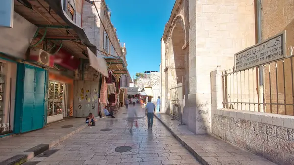 Kudüs 'ün eski kenti Kudüs' teki Kutsal Mezar 'ın yanındaki renkli çarşaf. İsrail zaman atlaması. Bu pazarda bir sürü insan geçiyor.