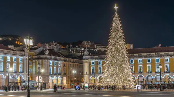 Lizbon 'daki ticaret meydanı, Noel' in aşırı hızıyla aydınlandı. Yükselen bir ağaç ve geceleri kutlayan kalabalıkla. Bir tepenin üzerindeki şenlikli atmosfer dekorasyonları ve tarihi mimarinin zamanı.