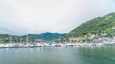 Como Gölü zaman çizelgesiyle manzara, Lombardy, İtalya. Evler ve botlar arka planda. Yaz gününde bulutlu bir gökyüzü.
