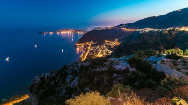 Günbegün geçiş zamanı, botlarla Akdeniz kıyılarının panoramik görüntüsü. Günbatımından sonra Fransız Rivierası 'ndaki Eze köyünün tepesinden ortaçağ evleri.