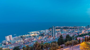 Monte Carlo 'nun panoramik şehir manzarası, Monako' dan güne geçiş zamanları yaz günbatımından sonra binaların çatıları ve trafik. Tepelerden gökyüzü görüntüsü.