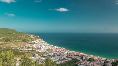 Portekiz 'in Susimbra kıyı kasabasında mavi bulutlu gökyüzü ve okyanusla hava manzarası