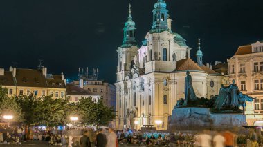Barok Aziz Nicholas Katedrali Prag ile anıt Oldtown meydanında Jan Hus gece timelapse aydınlatılmış. Turistler dolaşmak