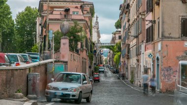 Roma sokakları, günlük aktivitelerle meşgul olan insanlarla dolu. Köprüsü ve arabaları olan eski bir bina. Roma, İtalya