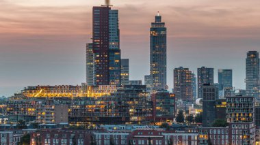 Rotterdam, Hollanda 'daki Katendrecht yarımadası ve Maashaven limanının hava ve gece geçiş zamanı. Şehir silueti modern gökdelenler ve geleneksel Hollanda rıhtım evleri