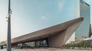 Rotterdam Merkez İstasyonu 'nun hiperlapesi, Hollanda, Güney Hollanda' daki ana demiryolu merkezi. Arka planında gökdelenler olan modern mimari ve kare zaman diliminde meşgul insanlar