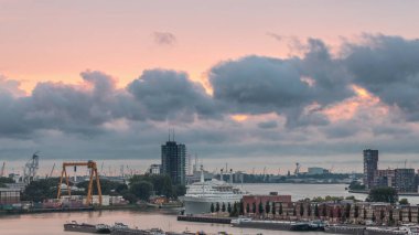 Maashaven Limanı 'nın hava zamanı, Hollanda Rotterdam' da günbatımında turuncu bulutlar. Rıhtım manzarası ve eski yolcu gemisi SS Rotterdam, şimdi Katendrecht 'e demirlemiş bir otel.