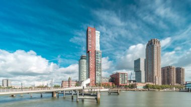 Hollanda, Rotterdam 'da bulunan ve yerel olarak Hoerenloper olarak bilinen Rijnhaven Köprüsü' nden Hiperlapse. Arka planda modern gökdelenleri ve bulutlu gökyüzü olan bir yaya ve bisiklet köprüsü