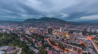 Saraybosna 'nın güney kesiminin gündüz ve gece hava görüntüsü. Gökdelenleri ve dağları olan gökdelenler. Gün batımından sonraki en yüksek kuleden. Bosna-Hersek ve Güneydoğu Avrupa.