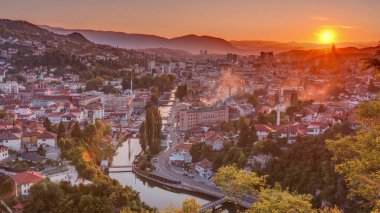 Saraybosna 'nın en popüler panoramik noktasından nehrin aktığı gün batımı manzarası. Sarı Kale (Zuta Tabija) yakınlarındaki yol, Vratnik