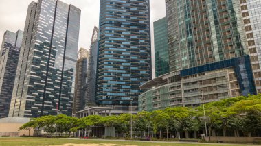 Singapur şehir manzarası. Modern megalopolis timelapse hyperlapse şehir merkezindeki gökdelenler ofis binaları. Cam yüzey ve bulutlar gökyüzü üzerinde yansımalar