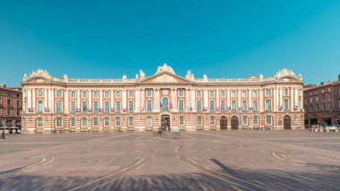 Capitole de Toulouse zaman çizelgesini gösteren panorama, Fransa 'nın Toulouse şehrinin tarihi belediye binası ve belediye kalbini, Capitole Meydanı' nda, çarpıcı mavi bulutlu gökyüzünün altında sergiliyor.