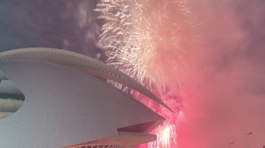 Valencia 'daki bir havai fişek gösterisi sırasında Palau de les Arts Reina Sofia' nın uçuş zamanı. Calatrava 'daki ikonik opera binasında fütürist kıvrımlar ve geceleri yansıyan havuzlar var. İspanya.