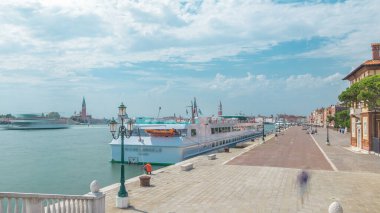 Panoramic view of the promenade Riva degli Schiavoni timelapse with tourists in San Marco of Venice in Italy. Cathedral of San Giorgio Maggiore on background. View from bridge