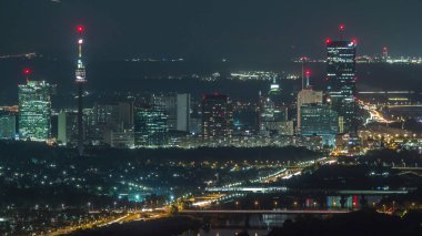 Viyana 'nın Skyline' ı Tuna 'dan Leopoldsberg Hava Saati' ne kadar uzanıyor. Nehir kıyısındaki köprüler, Donau City gökdelenleri ve akşam üzeri tarihi binalar.