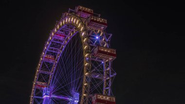 Wiener Riesenrad, Prater 'da gece programında. Avusturya' nın en eski ve en büyük dönme dolabı. Viyana şehrinin sembolü. Parktan görüntüle