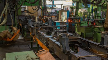 Konveyör montajı, traktörün gövdesini büyük endüstriyel fabrika zaman diliminde sahneleyecek. Çerçeve montajı kızgın perçinli metal bir masa üzerinde