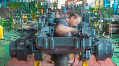 Konveyör montajı, traktörün gövdesini büyük endüstriyel fabrika zaman diliminde sahneleyecek. Çerçeve montajı, Chassis kurulumu ve diğer bölümler etrafındaki işçiler.