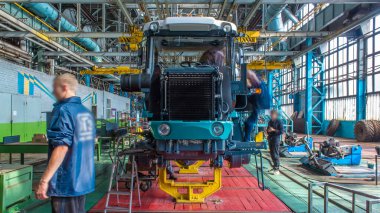 Konveyör montajı, traktörün gövdesini büyük endüstriyel fabrika zaman diliminde sahneleyecek. Çerçeve montajı, motor, egzoz borusu ve tekerlek kurulumu ve diğer bölümler.