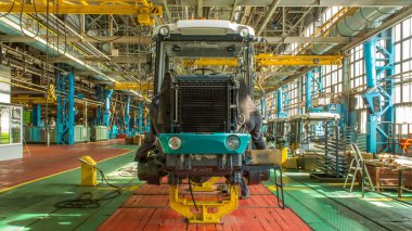 Konveyör montajı, traktörün gövdesini büyük endüstriyel fabrika zaman diliminde sahneleyecek. Çerçeve montajı, radyatör ve kabin kurulumu ve diğer parçaları olan motor.