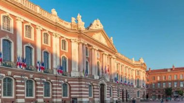 Capitole de Toulouse zaman ayarlı hiperlapse gösterilerinde Fransa 'nın Toulouse şehrinin tarihi belediye binası ve belediye kalbi mavi gökyüzünün altında yer alır. Gün batımında gölge kaplaması