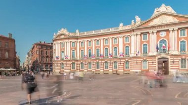Capitole de Toulouse zaman çizelgesini gösteren panorama, Fransa 'nın Toulouse şehrinin tarihi belediye binası ve belediye kalbini, Capitole Meydanı' nda, çarpıcı mavi bulutlu gökyüzünün altında sergiliyor.