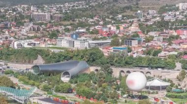 Yukarıdan Rike Park 'a. Tiflis 'in eski bir kasabasındaki modern şehir parkı. Şehirdeki dinlenme bölgesinde yeşil ağaçlar ve çimenler. Huzur Köprüsü ve konser salonu. Georgia