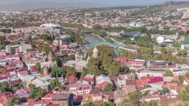 Georgia 'nın Tiflis şehrinde ahşap balkonları ve kırmızı çatıları olan renkli geleneksel evler. Barış ve nehir köprüsü ile yukarıdan bak