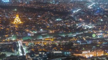 Tiflis 'in Kutsal Üçlü Katedrali, Gürcistan' ın Tören Sarayı ve Rike Park hava sahasındaki konser salonu ile şehir manzarası. Tiflis, Georgia. Arka plandaki evler ve caddelerdeki trafik