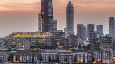 Rotterdam, Hollanda 'daki Katendrecht yarımadası ve Maashaven limanının hava ve gece geçiş zamanı. Şehir silueti modern gökdelenler ve geleneksel Hollanda rıhtım evleri