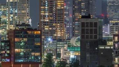 Rotterdam şehir merkezi, Hollanda 'daki modern binaların uçuş zamanı. Finans bölgesinde aydınlık kuleler ve gökdelenler. Parlayan pencereler, parlak bir gece silueti oluşturuyor.