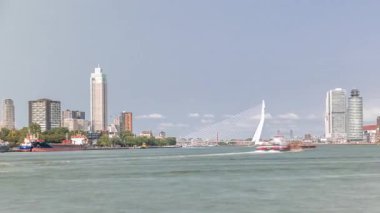 Hollanda, Rotterdam 'daki Maas Nehri' ni kapsayan Kuğu adlı Erasmus Köprüsü zaman çizelgesi panoraması. Hollands 'ın en büyük kablo destekli basküle köprüsü gökdelenleri, tekneleri ve bulutlu mavi gökyüzü