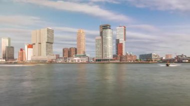 Panorama, Nieuwe Maas River bankasından Wilhelminapier ve Kop van Zuid 'e kadar olan zaman çizelgesini gösteriyor. Modern gökdelenler, gemi terminali ve Erasmus Köprüsü, kıyıdan geçen tekneler.