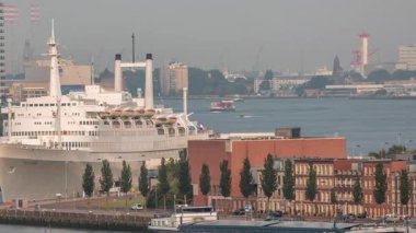 Hollanda, Rotterdam 'da sabah saatlerinde Maashaven Limanı' nın uçuş zamanı. Rıhtımın ufuk çizgisi ve eski bir yolcu gemisi olan SS Rotterdam, şimdi Katendrecht 'e demirlemiş bir otel.