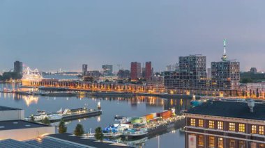 Güneş doğmadan önce Maashaven 'daki kuleler üzerindeki hava manzarası demirli gemilerle, Katendrecht ve Maas Nehri' yle, Rotterdam 'la geçiş zamanlarını gösteriyor. Aydınlatılmış fabrika ofis ve olay alanına dönüştürüldü