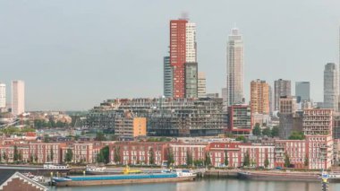 Rotterdam, Hollanda 'daki Katendrecht Yarımadası ve Maashaven Limanı' nın panoramik zaman çizelgesi. Sabah şehir silueti, modern gökdelenler ve Hollanda kıyısı evleri olan eski fabrikalar.