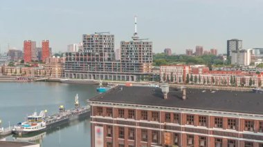 Rotterdam 'daki Maashaven' da, iç kısımlara demirlemiş gemiler, Katendrecht ve Maas Nehri 'nin üzerindeki hava zaman ayarlı görüntüsü. Eski fabrika ofis ve etkinlik alanına dönüştü. Hollanda
