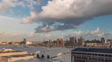 Arka planda Katendrecht ve Maas Nehri 'nin bulunduğu Maashaven üzerindeki hava zaman dilimi görüntüsü. Eski fabrika ofis ve etkinlik alanına dönüştü. Gökdelenlerin üzerinde dramatik bulutlu gökyüzü. Yollar boyunca trafik