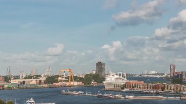 Arka planda Katendrecht ve Maas Nehri 'nin yer aldığı Maashaven' ın havadan görüntüsü. Sıcak sabah ışığıyla gökdelenlerin üzerinde dramatik bulutlu bir gökyüzü. Arkaplanda kargo portu