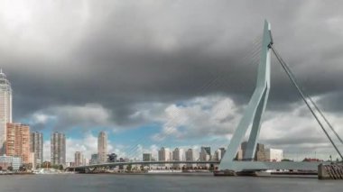 Hollanda, Rotterdam 'daki Maas Nehri' ni kapsayan Erasmus Köprüsü zaman atlaması. Hollanda 'nın en büyük kablo destekli basküle köprüsü gökdelenleri, tekneleri ve dramatik bulutlu arkaplanı