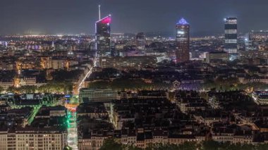 Geceleri Fourviere Hill 'den gökdelenlerle Lyon' un panoramik hava manzarası. Ufuk çizgisinde Rhone Nehri ve ikonik kent simgeleri yer alıyor. Evler çatılar ve caddelerde trafik