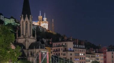 Aziz George Kilisesi, Quais de Saone ve Fourviere Bazilikası 'nın Fransa' nın Vieux Lyon kentindeki bir yaya köprüsünden hızlandırılmış zaman aşımına uğraması, geceleri tarihi mimari, yansımalar ve manzaralı nehir manzarası sergilenmektedir.