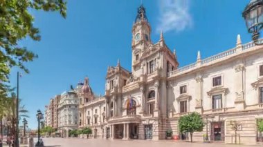 Valencia Belediye Binası Ajuntament de Valencia zaman atlaması Plaza de Ayuntamiento 'da. Mavi gökyüzünün altında saat kulesi olan tarihi bir bina. İspanya 'nın ana meydanında gezinen insanlar