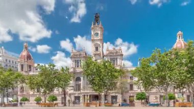 Valencia Belediye Binası Ajuntament de Valencia zaman atlaması Plaza de Ayuntamiento 'da. Mavi bulutlu gökyüzünün altında saat kulesi olan tarihi bir bina. İspanya 'nın ana meydanında gezinen insanlar