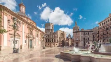 Valencias Plaza de la Virgen 'in panoramik zaman atlaması, Turia Fountain, Cathedral ve Basilica de la Virgen de los Desamparados' un mavi bulutlu gökyüzü altında sergilenmesi
