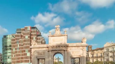 İspanya, Valencia 'da La Porta de la Mar zaman atlaması. Bir zamanlar ortaçağ duvarlarının bir parçası olan bu neoklasik kapı kalabalık bir kavşağın üzerinde duruyor. Gün batımında parlak bir gökyüzünün altında değerli bir şehir simgesi.