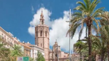 Valencia, İspanya 'da Plaza de la Reina' nın panoramik zaman atlaması. Tarihi bir kilise kulesi, hareketli kafeler ve sıcak Akdeniz semaları altında palmiyeleri olan merkezi bir çeşme..